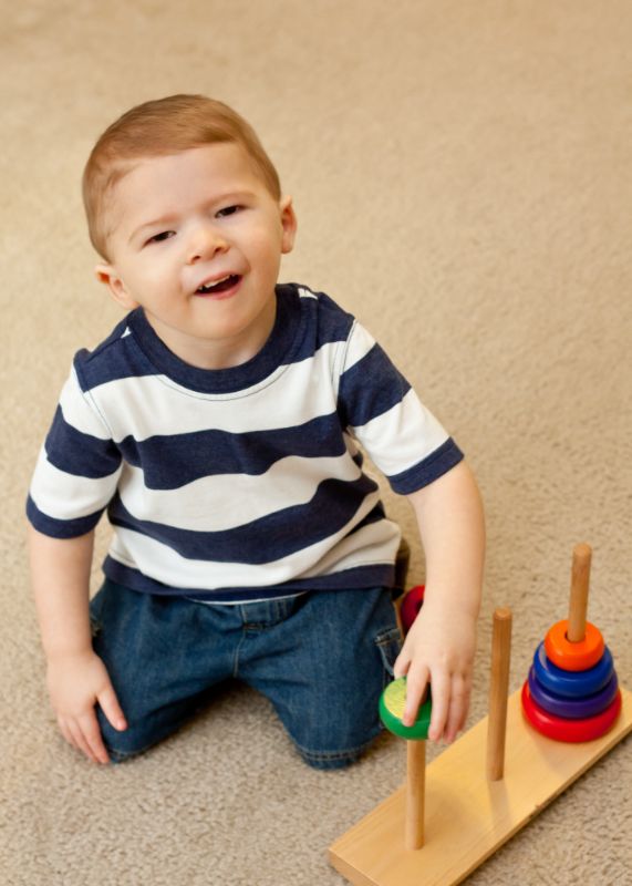 Developmentally delayed child with stacking toy
